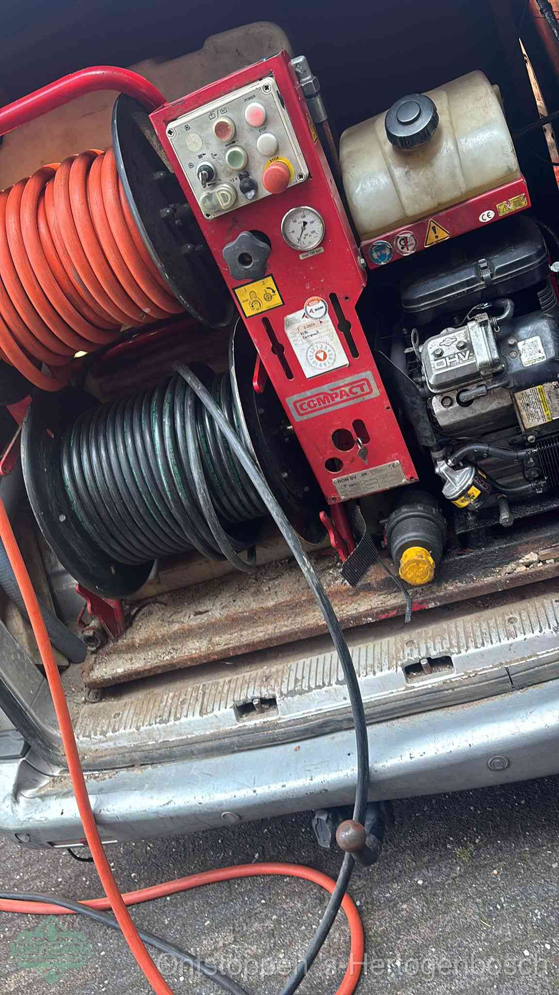 Een rood hogedruk-rioolreinigingstoestel in de laadbak van de bedrijfsbus, apparatuur voor een hardnekkige afvoerverstopping in s-Hertogenbosch