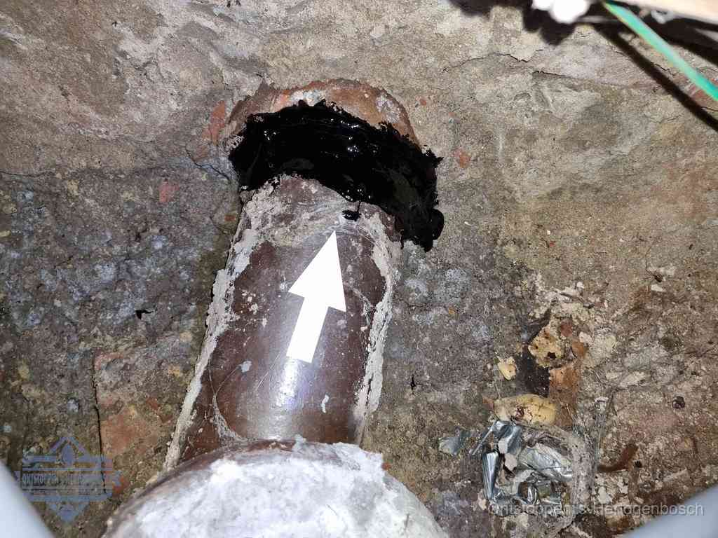 Een oude gres rioolbuis met een beschadigde koppeling onder de vloer, oorzaak van terugkerende structurele wc-problemen in s-Hertogenbosch